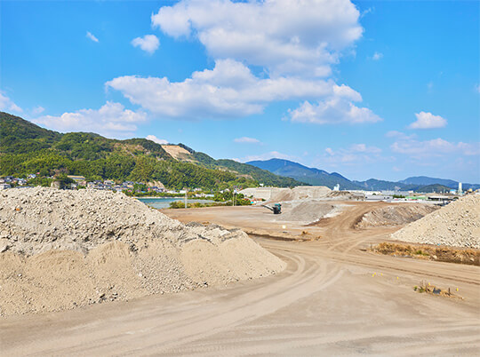 福岡県北九州市にある産業廃棄物リサイクルプラントに積まれた産業廃棄物と搬入経路の様子